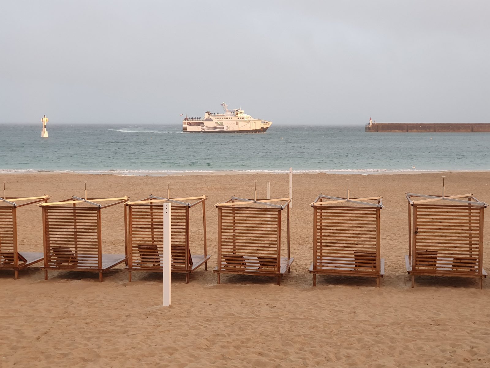 Cabines de plage en bois sur la Grande Plage de Quiberon, navette maritime au large